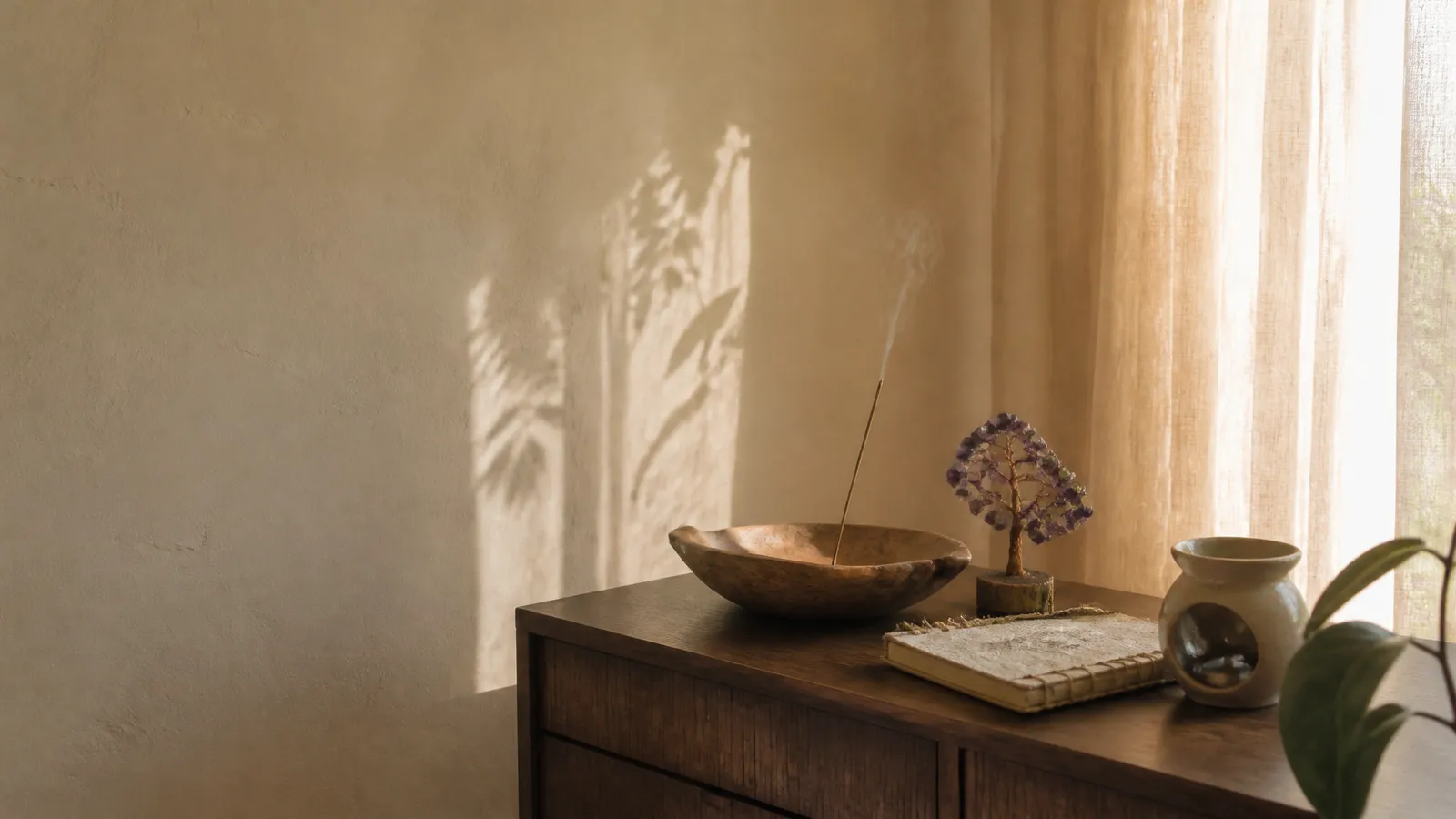 Rustig hoekje thuis met wierook, een houten schaal, een edelsteenboompje en een oliebrander Rustig hoekje thuis met wierook, een houten schaal, een edelsteenboompje en een oliebrander